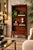 Elegant 1960s Hollywood Regency bookcase in the style of Baker Furniture, featuring a warm wood finish accented with...
