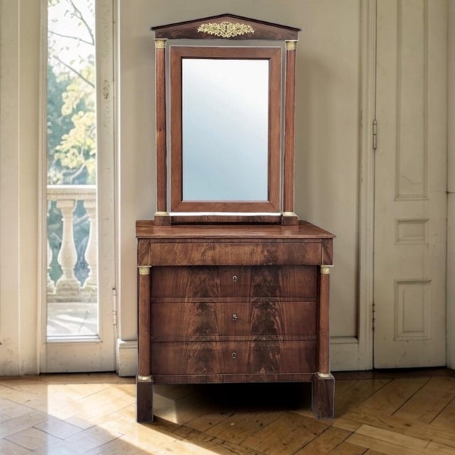 Crafted in France during the first half of the 19th century, this elegant Empire period chest with its original mirror...