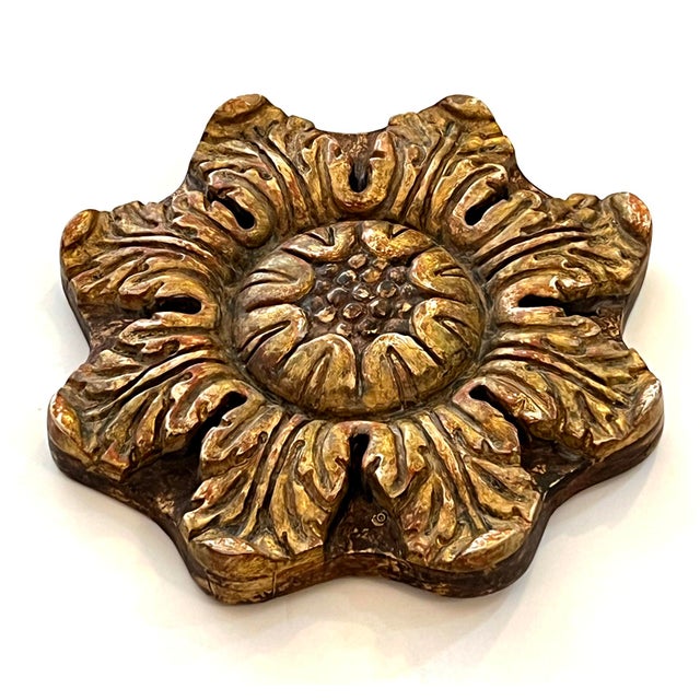 the stylized carved wooden rosette centering a circular reserve surrounded by a wreath of scrolled acanthus leaves all in...