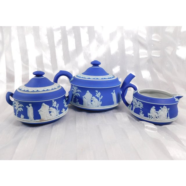 This is a Wedgwood Jasperware Teapot that is cream color on Portland Blue with the matching covered sugar bowl and...