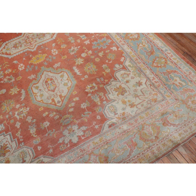 An early 20th century Turkish Oushak with a traditional medallion and border motif on an orange peel colored ground. The...