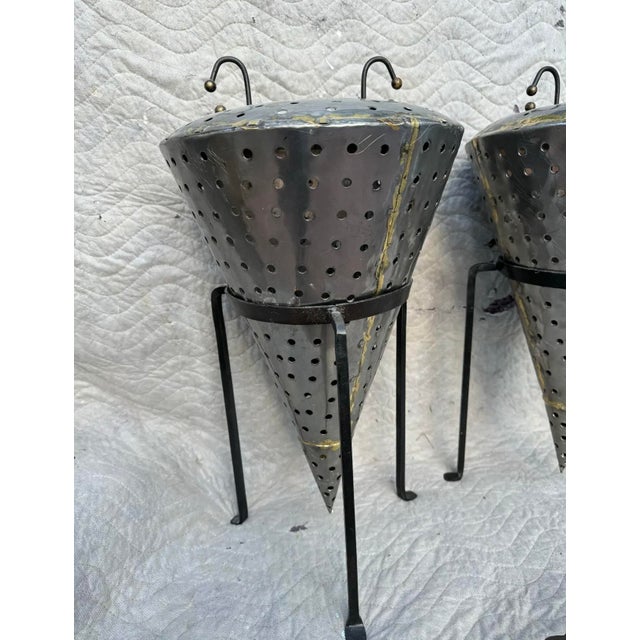 Vintage industrial candle holders and stands . Done in a cone shape in stainless steel with iron stands . Acquired from an...
