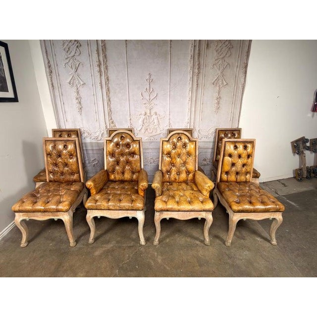 A set of eight French Louis XV-style leather tufted dining chairs, comprising six side chairs and two armchairs, embodying...
