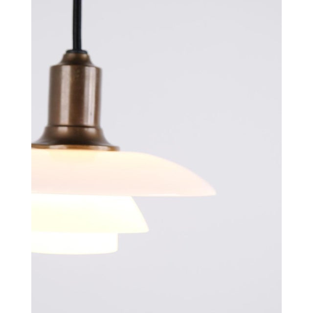 Ph 2/1 pendant lamp designed by poul henningsen and manufactured by louis poulsen. The lamp is made of burnished brass...