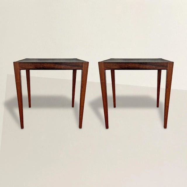 A stylish and straightforward pair of Danish Modern rosewood end tables with square tapered legs and black composition...