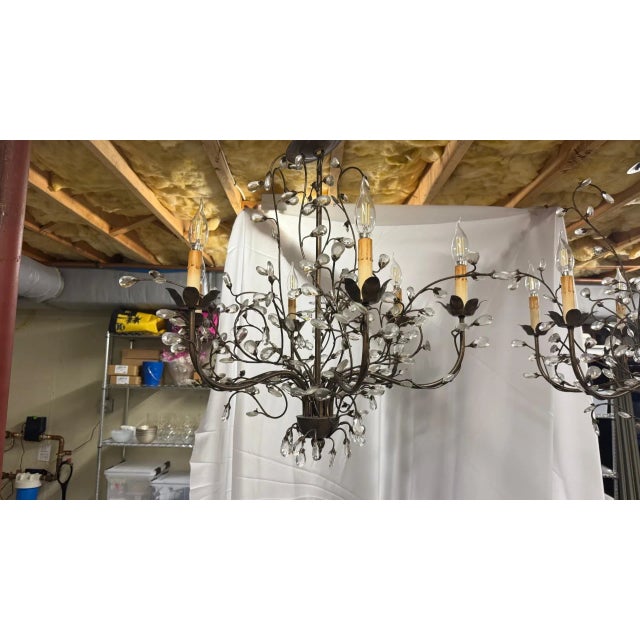 Romantic and sculptural, this pair of wrought iron chandeliers features hand-forged branches adorned with faceted crystal...