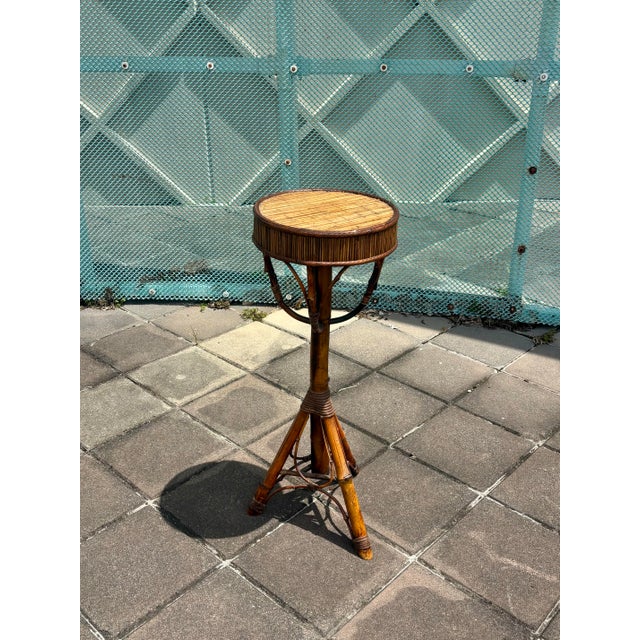 A sculptural vintage bamboo and cane pedestal, handcrafted with a tall tripod base and beautifully detailed woven and...