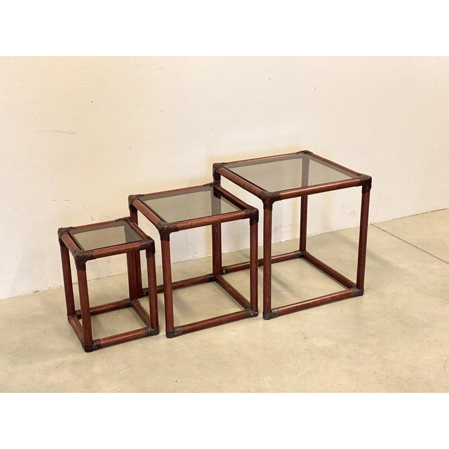 Tris of 70s bamboo tables, leather ties and smoke glass tops.