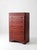 A handsome early 20th-century Art Deco dresser featuring a warm reddish-brown finish, a rounded waterfall top, and elegant...