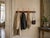 Antique wall-mounted coat rack in wood and brass, dating from the 1900s. It consists of an elegant molded wooden frame,...