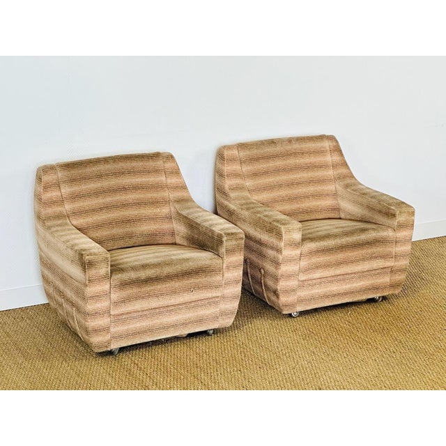 An elegant pair of armchairs from the 1970s, featuring a design typical of the era, combining comfort and generous lines....
