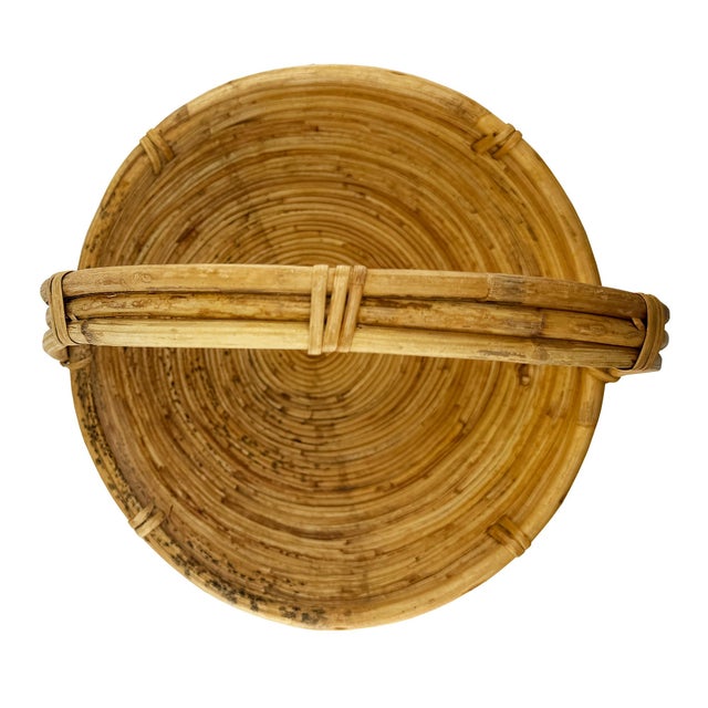 A beautifully handcrafted vintage pencil reed basket featuring a gracefully arched bentwood handle and tightly coiled...