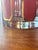 Vintage mid-century modern lowball glasses feature vertical pinkish-red panels accented with 22-karat gold geometric trim...
