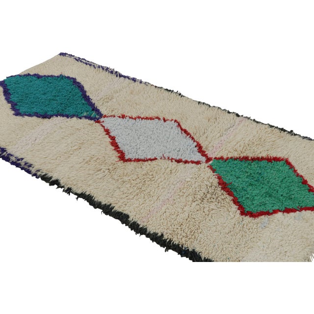 Hand-knotted in wool and circa 1950-1960, this vintage 3x6 Moroccan runner rug is believed to hail from the Azilal tribe....