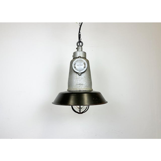 Large industrial factory hanging lamp made by Cortem Milano in Italy during the 1960s. It features a cast aluminium top, a...