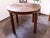 Elegant round dining table from the 1960s, showcasing the refined craftsmanship of the mid-century era. The tabletop is...