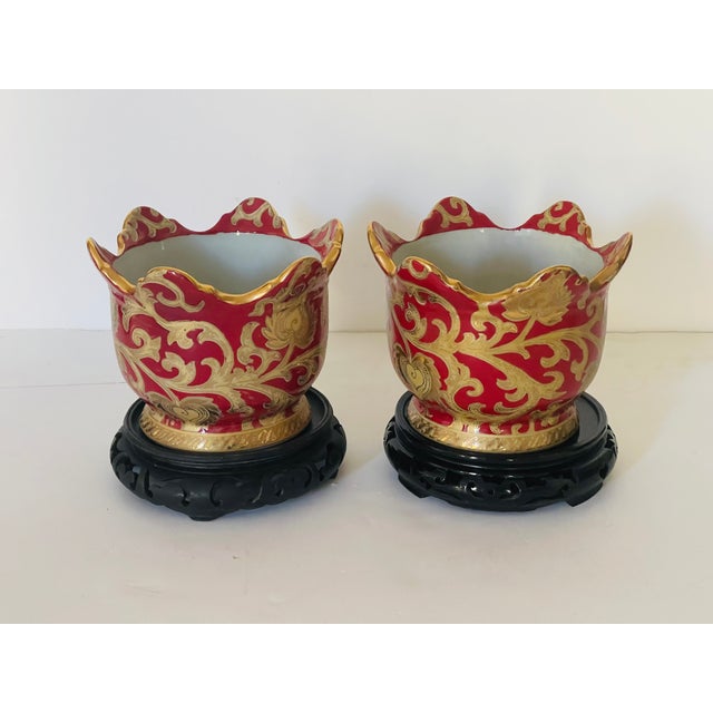 Vintage Chinese porcelain planters in gold and red with two matching wooden stands.