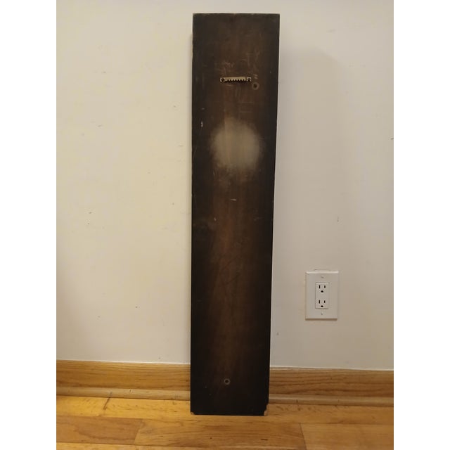 This decorative wall sculpture features a finely carved female figure in flowing classical robes, rendered in rich warm...