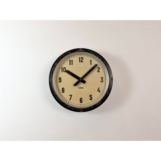 This wall clock was manufactured by IBM in the United States in the 1950s. It features a black metal frame, an iron...