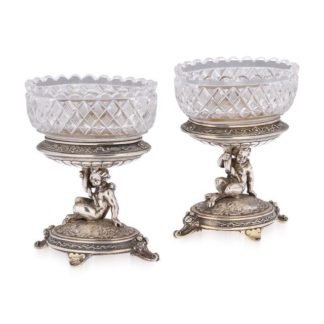 19th Century Victorian pair of silver figural salts, each piece raised on an oval domed base on four scrolling feet, each...