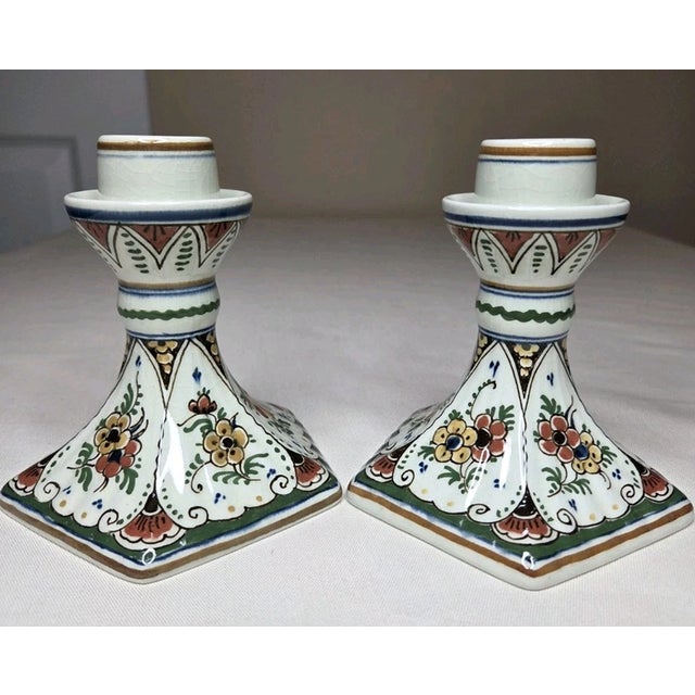 Vintage pair of Delft hand-painted ceramic candlestick holders featuring a charming floral design and classic Delft-style...