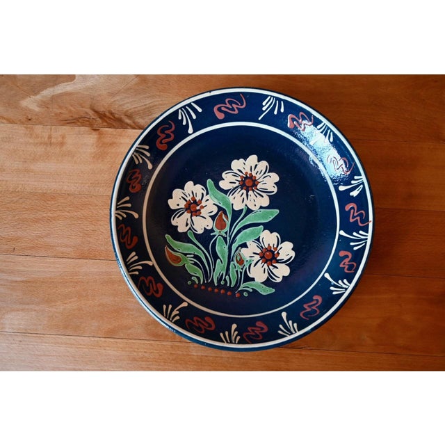 This glazed earthenware dish is a typical example of Soufflenheim pottery. A central bouquet is surrounded by stylized...