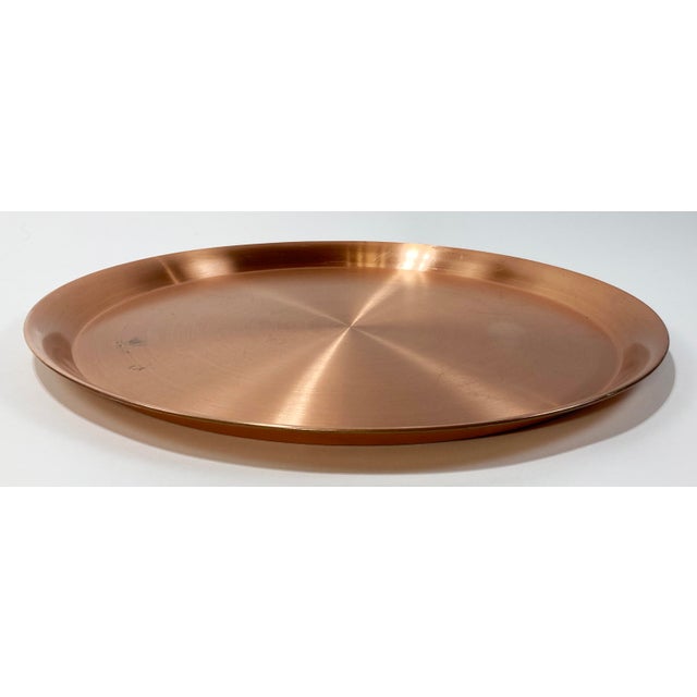 Large round copper tray with great patina reflective of age and use. Measures 17.5"dia with a solid 1"H lip. Natural age...
