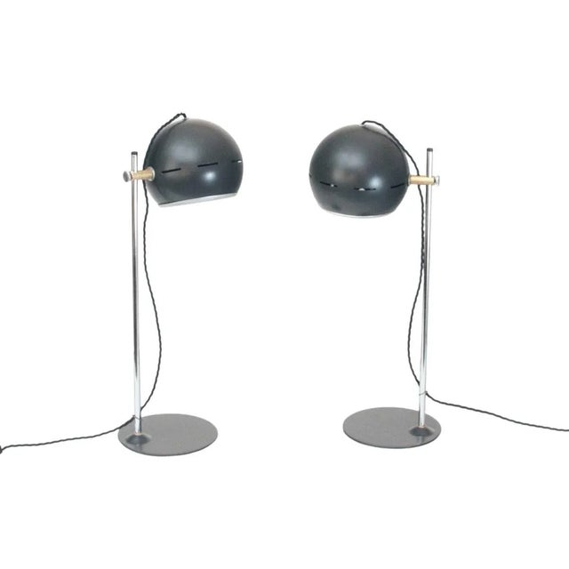 Pair of table lamps with head adjustable in height and direction. Painted black slate and polished metal. Italy, 1970s....