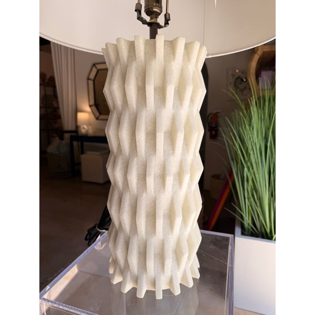 This modern sculptural table lamp makes a sophisticated statement with its striking geometric silhouette and tactile...