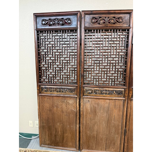 Design Plus Gallery presents a Carved Wood Folding Screen. The screen has open fretwork lattice panels, pierced scrollwork...