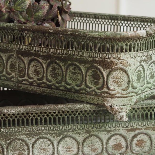 Two-piece set of handcrafted metal planters with a continuous relief decoration, openwork gallery rim, and artificially...