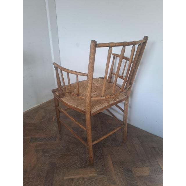 A charming late 19th-century English ash Sussex armchair, circa 1880–1900, of traditional country form with turned...