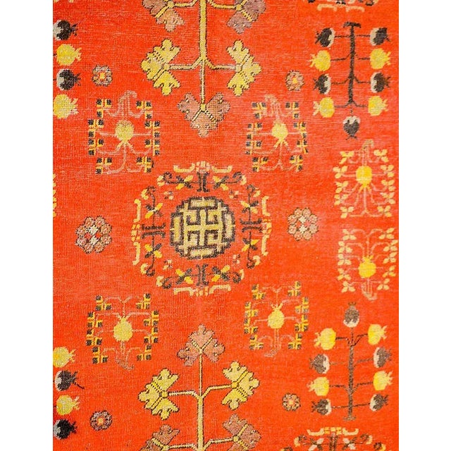 A beautiful early 20th century Central Asian Khotan rug with a rich crimson field of pomegranate, trees-of-life, and...