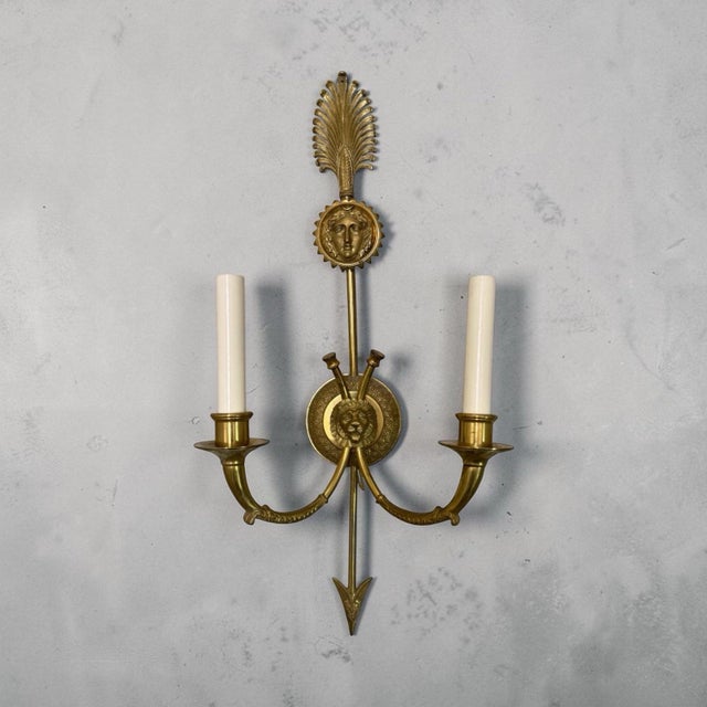 Beautiful pair of brass sconces in the manner of Andre Arbus. Central arrow with a starburst visage, sweeping arms meeting...