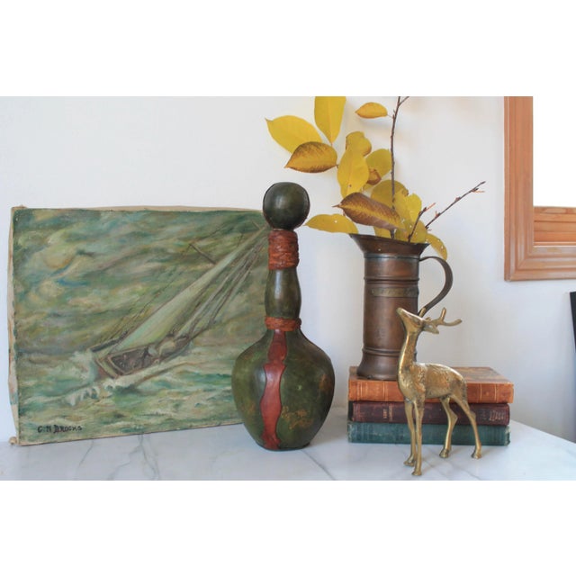 Beautiful olive green and brown leather decanter with gold accents. Marked "Made in Italy" on the bottom. Some minor age...