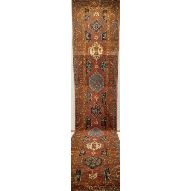 "A captivating antique Heriz Serapi runner from the early 20th century, handwoven in Northwest Persia and dated 1327 in...