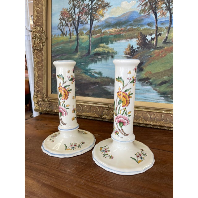 This pair of vintage ceramic candlesticks by Gien France features hand-painted floral motifs in rich tones of green, pink,...