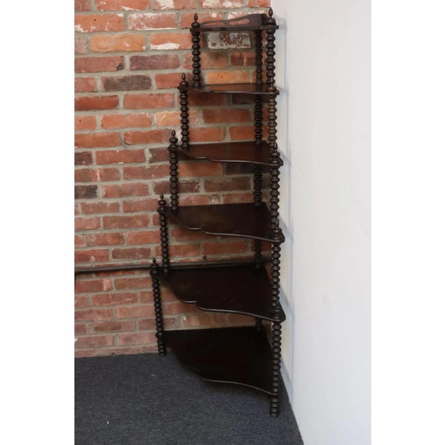 Stained mahogany corner shelf with spool/bobbin-form/turned wood posts supporting six 'mustache-form' tiers (ca. early...