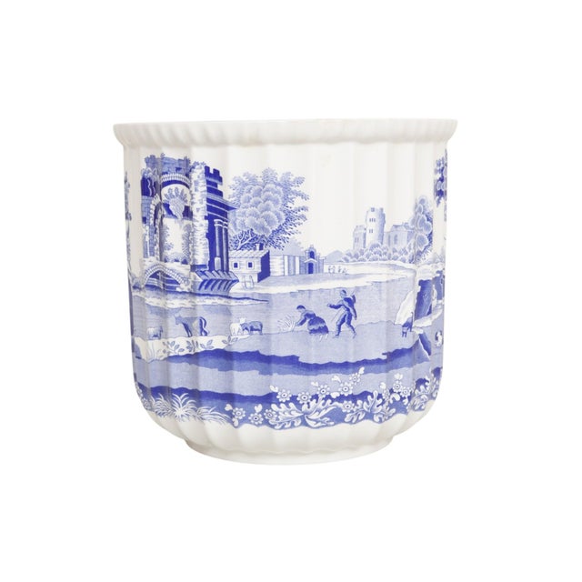 A blue and white porcelain planter made by Spode, in their iconic British “Blue Italian” pattern. Fluted sides are...