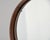 Found in Italy, this mid-century modern mirror floats within a circular, warm walnut frame. The rounded, trough-profile...