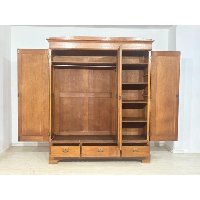 For sale is this beautiful, three-door Art Nouveau wardrobe made of oak with a beveled mirror and brass fittings, as seen...