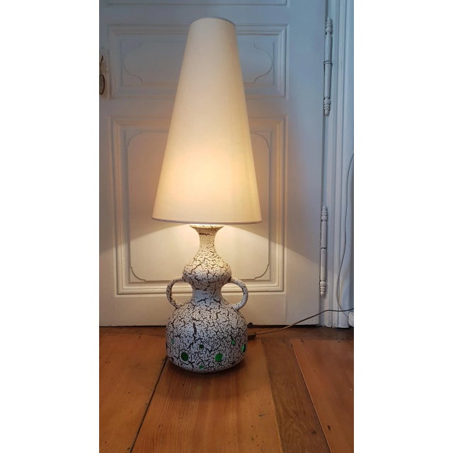 This large lamp from the 1960s has an enameled ceramic base and structure, which gives a textured and cracked appearance,...