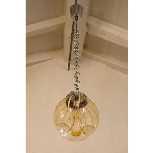 Mid-century 1970s pendant with central globe made in very fine murano blown glass, which makes the chandelier almost...