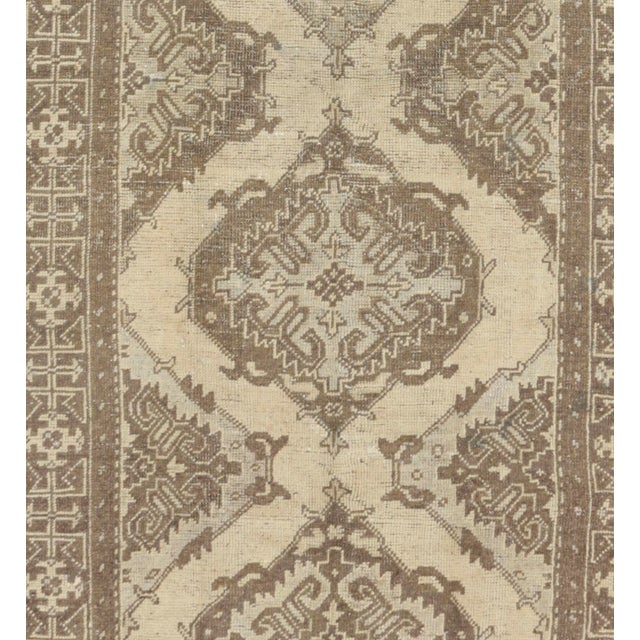 This vintage Turkish rug, handwoven circa 1940, features a warm color palette that exudes a cozy ambiance. Crafted from...