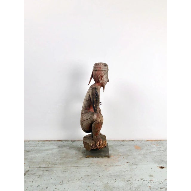 A late 19th / early 20th century Southeast Asian wood carving of a drummer, with traces of original red paint, circa 1900.