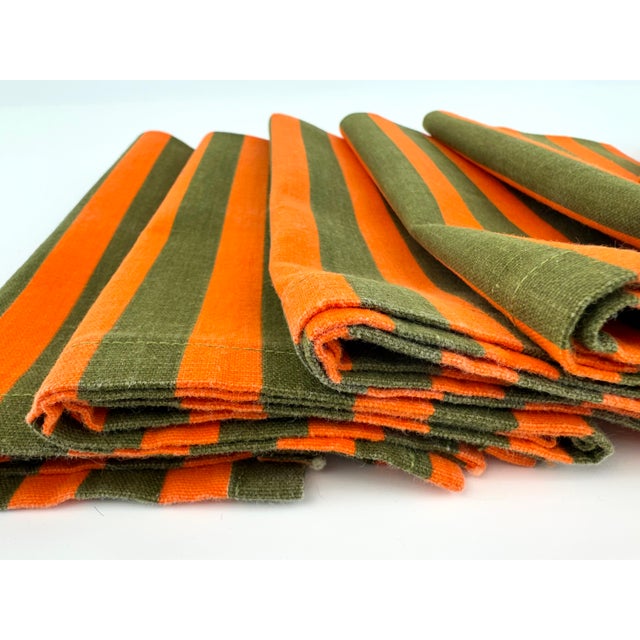 Set of six mid-century cotton napkins featuring bold alternating stripes in vibrant orange and deep olive green. The...