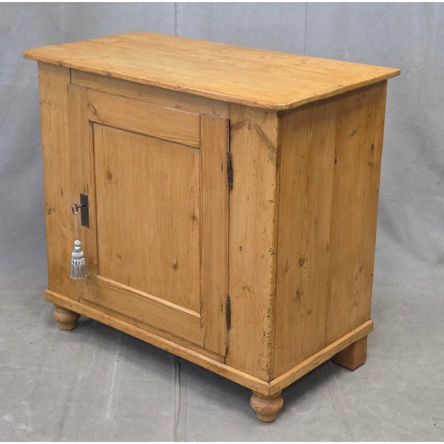 A charming and functional antique English pine single door cupboard with working key and original hardware. The cabinet...