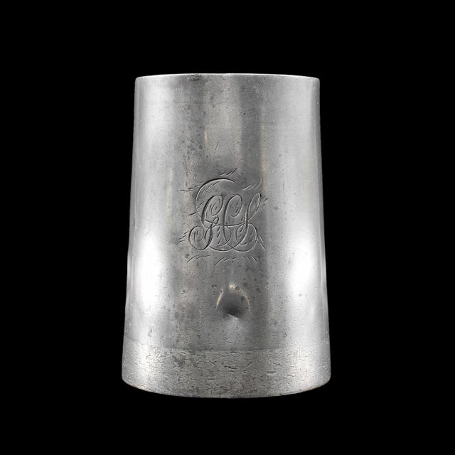 This is an antique tavern's pint tankard. An English, pewter drinking jug with glass base, and personal monogram, dating...