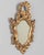 A French Baroque style giltwood mirror with cartouche shape framed by undulating borders. Hand-carved solid wood with...