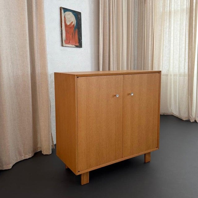 This streamlined Mid-Century Modern two-door, high boy dresser cabinet is by George Nelson for Herman Miller. Nelson...